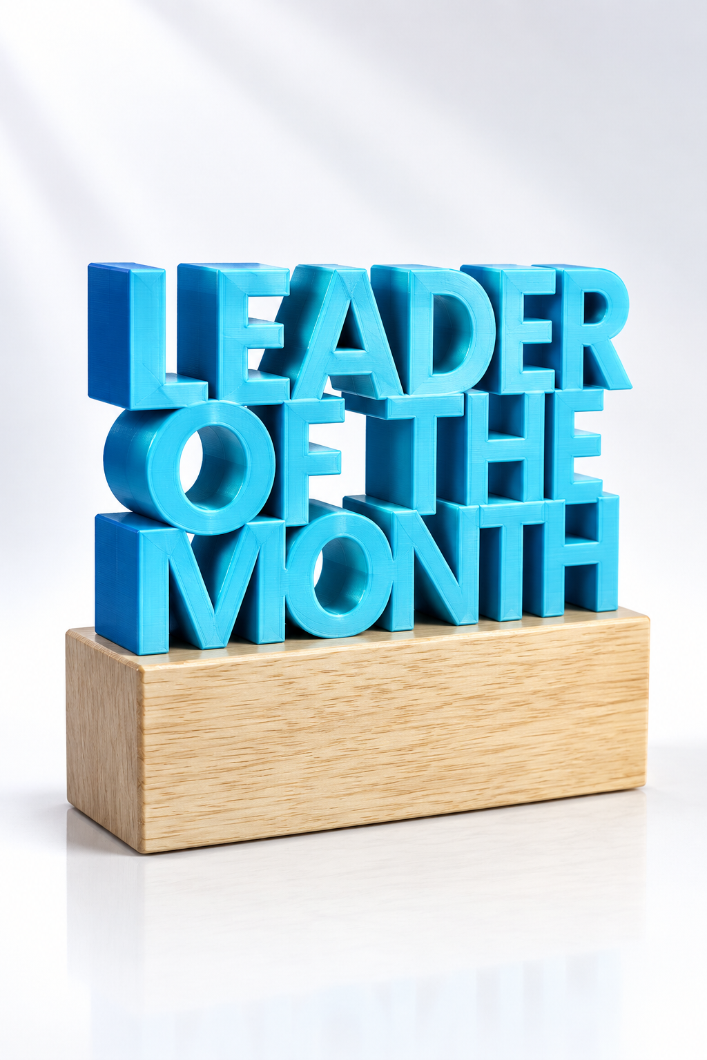 Cyan Leader of the Month dimensional award on a light wood base